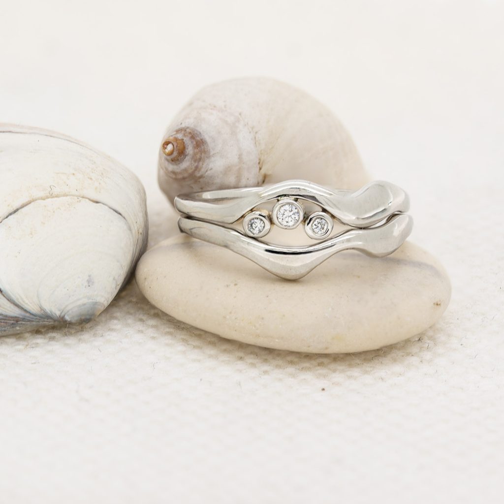 Sea inspired flowing tideline wedding and engagement rings